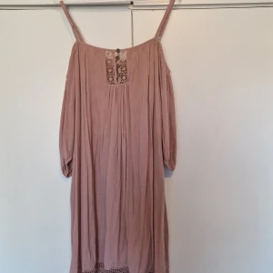 Rosa klänning från Bodyflirt - Säljer en söt rosa klänning från Bodyflirt med spetsdetaljer och knappar framtill. Klänningen har långa ärmar och smala axelband, perfekt för en avslappnad stil. 💖