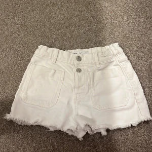 Vita shorts med fransar - Snygga vita shorts med fransiga kanter och två knappar framtill. De har en elastisk midja och praktiska fickor både fram och bak. Perfekta för en avslappnad sommarlook! Skicka först om ni skulle vilja köpa!💕