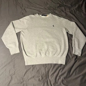 Grå sweatshirt från Polo Ralph Lauren - Säljer en stilren grå sweatshirt från Ralph lauren då jag har en liknande. Tröjan är rätt så ny andvänd 3-4 gånger köpt för ca 1 månad så skicket är 10/10. Ny priset ligger på 2095. Skriv om frågor eller fler bilder😁