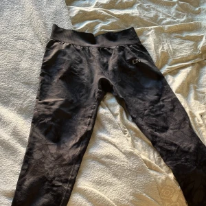 Mörka träningsleggings från ICANIWILL - Snygga spräckliga träningsleggings från ICANIWILL med ett diskret mönster. De har en hög midja och är tillverkade i ett stretchigt material som ger bra rörelsefrihet. Perfekta för gymmet eller löprundan. Säljer för de är för stora för mig💕
