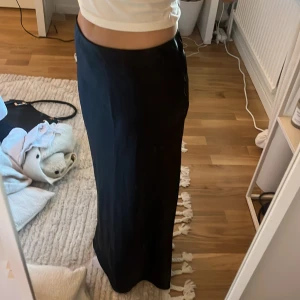 Svart långkjol - Säljer en svart silkes långkjol. Den är för liten i midjan därför säljer jag den, inget fel på den och bara använd fåtal gånger. 