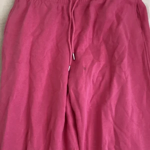 Rosa mjukisbyxor med snörning - Säljer ett par bekväma rosa mjukisbyxor med elastisk midja och snörning. Perfekta för en avslappnad dag hemma eller en snabb tur till affären. Byxorna har en mjuk insida för extra komfort. Och två fickor på sidorna 