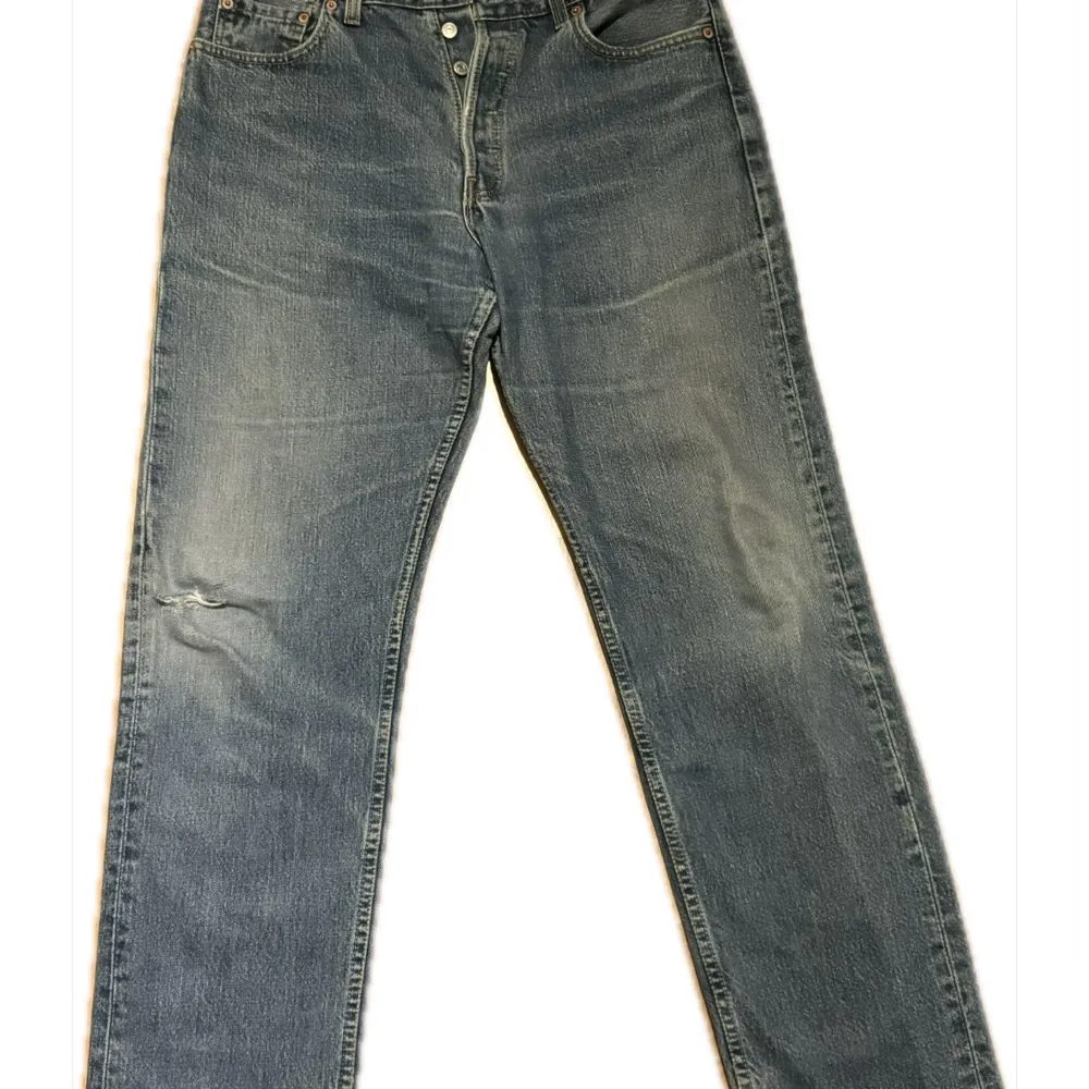 Säljer ett par klassiska Levi's 517 jeans i blå denim. Dessa jeans har en rak passform och är tillverkade i slitstarkt jeansmaterial. Perfekta för en avslappnad stil. Har slitningar vid ena knät och längst ner. Storlek w33l32. Farkut & Housut.