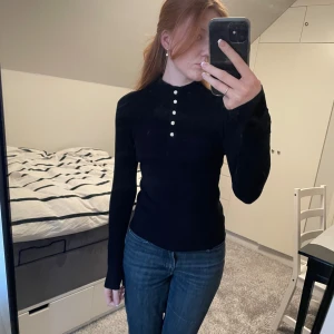 Svart polotröja - Säljer en stilren svart långärmad tröja från Vero Moda med snygga kristallknappar🤍