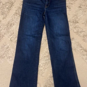 Mörkblå jeansbyxor - Snygga mörkblå jeansbyxor från 157 med klassisk femficksdesign och kontrasterande sömmar. Byxorna har en rak passform och är perfekta för en avslappnad stil. De har en knappgylf och är tillverkade i ett slitstarkt denimtyg.