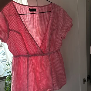 Röd- och vitrandig blus - Säljer en söt röd- och vitrandig blus med omlott-design och korta ärmar. Blusen har en elastisk midja som ger en fin passform😊😊 priset diskuteras gärna