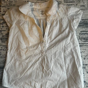 Vit kortärmad skjorta från LOGG - Jag säljer en vit skjorta som har ett fint blommönster på. Kontakta mig för mer info! Pris kan diskuteras 