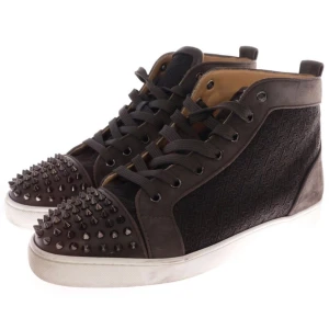Christian Louboutin Bruna sneakers med nitar - Snygga bruna sneakers med nitar på tån och en unik röd sula. Skorna har snörning och en cool textur på sidorna. Perfekta för att ge din stil en edgy touch.