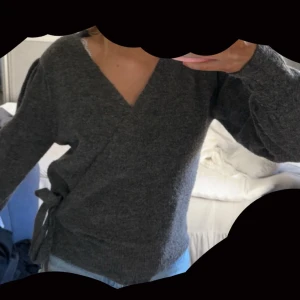 Grå omlottkofta från ICHI - Säljer en mysig grå omlottkofta från ICHI. I storlek XS Koftan har en v-ringad design och långa ärmar med puffiga detaljer. Perfekt för kyliga dagar och ger en stilren look. Passar bra till både jeans och kjol. Skicka vid fler frågor eller så anmars är det bara att köpa!!❣️🥰🩷använd ca 2-3 gånger så som ny!köpt för 600kr!