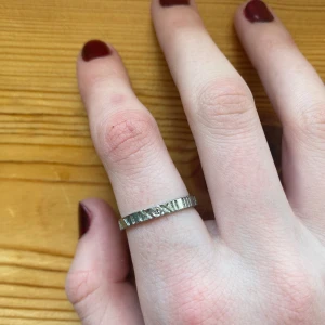 Silverring med mönster - En fin silver ring med romerska siffror på och en liten diamant. Perfekt för att ge en extra touch till din outfit. Passar både till vardag och speciella tillfällen. På andra bilden ser man hur stor den är i jämförelse med en 2 krona. Läs min bio innan du köper✨