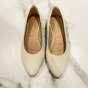 Vita ballerinaskor från Anna Field - Snygga vita ballerinaskor från Anna Field i storlek 36🥰 Använda några gånger men i fint skick! Har klistrat fast ett inlägg vid hälen för att dem va förstora för mig, men de går att ta bort lätt!🙌🏻