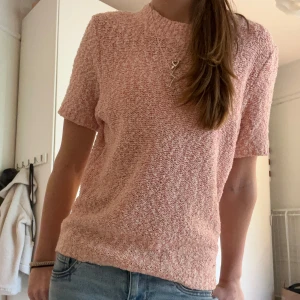 Rosa stickad topp från Holly Whyte by Lindex - Säljer en söt rosa stickad topp från Holly Whyte by Lindex. Toppen har korta ärmar och en rund halsringning. Perfekt för en avslappnad stil med en touch av elegans. Passar bra till både jeans och kjol. Knappt använd och inga tecken på användning! Storlek S