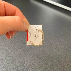 Guldörhänge med kedja och stenar - Guldörhänge med en kedja som kopplar ihop två delar - ett stift och en ring. Helt oanvänt!