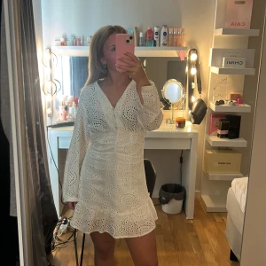 Vit broderad kortklänning från Zara - Superfin vit kortklänning från Zara i storlek Xs med dragkedja på sidan och knappar fram, den är i jättebra skick och används fåtal gånger. Säljer på grund av att den inte kommer till användning och blivit förliten💞