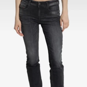 Svarta straight jeans från Diesel - Säljer ett par svarta jeans från Diesel med raka ben och klassisk femficksdesign. Jeansen har silverfärgade knappar och en snygg tvättad look. Modellen är straight fit och midwaist, perfekta till sneakers eller boots. Står storlek 30 men som referens är jag storlek 34, bara att skriva om ni vill ha mått💕