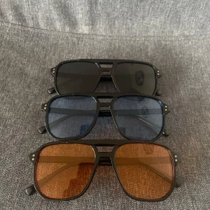 3 pack glasögon - Säljer tre par stilrena glasögon. Ett par svarta, orangea & blåa alla tonade och är perfekta till varma sommarkvällar. Perfekt för dig med stil eller vill få. Skick: helt nya!👓