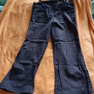 Bruna vida linnebyxor från H&M, strl 40 - Snygga bruna byxor från H&M i storlek 40. Vida ben och klassisk passform med hällor för bälte och dragkedja fram. Tillverkade i bomull och linne, perfekta för dig som gillar en avslappnad men trendig look.