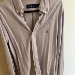 Ljuslila skjorta från Ralph Lauren - Klassisk ljuslila skjorta från Ralph Lauren med broderad logga på bröstet. 