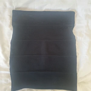 Svart tight kjol från Tally Weijl - Säljer en svart, tight kjol från Tally Weijl i kort modell. Kjolen har en stilren design med horisontella sömmar och är gjord i ett stretchigt material som sitter snyggt på kroppen. Perfekt för dig som gillar en enkel men trendig look