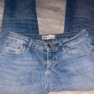 Ljusblå jeans från Zara, strl 36 - Säljer ett par ljusblå jeans från Zara i klassisk femficksmodell. Jeansen har normal passform, raka ben och snygga slitningar för en avslappnad look. Tillverkade i bomull med en skön jeanskänsla. Perfekta till sneakers eller boots. Tyvärr har dem hål där bak😢Säljer till nån som kanske kanske kan laga den. Synd o slänga då den var mina favorit jeans och dem inte säljs längre 