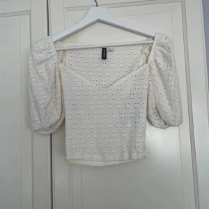 Vit blus med puffärmar och broderi - Superfin vit blus från H&M med broderade hålmönster och puffiga korta ärmar. Mycket bra skick. Storlek XS: 