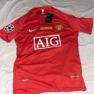 Manchester United Ronaldo 7 Finaltröja - Röd Manchester United fotbollströja från Nike, med Ronaldo 7 på ryggen och AIG som sponsor framtill. Tröjan har klubbmärke, Champions League-märke på ärmen och detaljer om Moskva-finalen 2008. Finns både med korta och långa ärmar. Tillverkad i lätt funktionsmaterial.