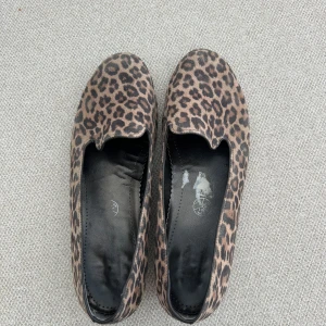 Leopardmönstrade ballerinaskor - Snygga ballerinaskor/ loafers med leopardmönster i bruna och svarta toner. Skorna har rund tå och platt sula, samt svart innersula. Perfekta för dig som vill sticka ut med ett djurmönster och ändå hålla det bekvämt.