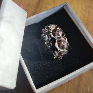 Vintage ring  - Superfin tjej ring i 925 sterling silver med detaljerade blommor runt hela ringen. Varje blomma har en liten lila sten i mitten. Inre diameter är ungefär 20mm Omkretssen är ungefär 55mm. Använd fåtal gånger men har varit väl omhändertagen. Vikt 4g 