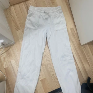 Vita mjukisbyxor från 157, storlek M - Vita mjukisbyxor från 157 med elastisk midja och snörning. Byxorna har två stora fickor fram och två bak, raka ben och är gjorda i mjukt bomullstyg. Perfekta för chill dagar eller när du vill vara extra bekväm.