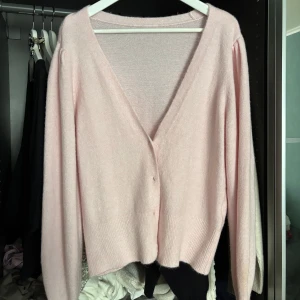 Ljusrosa kofta med v-ringning - Supermjuk ljusrosa kofta med djup v-ringning och knappar framtill. Jättesöt!! Ser inga defekter använd fåtals gånger💓storlek L men passar även de som är storlek M 