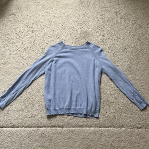 Ljusblå stickad tröja från Mango - Ljusblå stickad tröja från Mango Basics i storlek S. Tröjan har rund halsringning, långa ärmar och ribbade muddar. Snygga stickade detaljer längs ärmar och axlar ger en clean men ändå intressant look. Materialet är tunt och skönt.