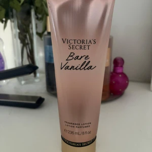 Victoria's Secret Bare Vanilla lotion - En helt oanvänd och lyxig doftlotion från Victoria's Secret i Bare Vanilla-varianten. Kommer i en glansig, ljusrosa tub med gulddetaljer och rymmer 236 ml. Ger huden en söt vaniljdoft och silkeslen känsla.