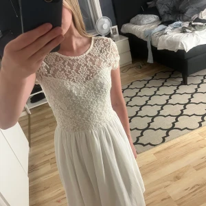 Vit klänning  - Är i storlek 34. Har blommiga mönster både fram och bak. Klänningen har en dragkedja bak. Den har dock tre fläckar men tycker inte att man ser de när man har på sig den. Fläckarna går säkert bort med vanish eller galltvål men har inte orkat gjort de för använder inte.