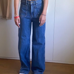 Blåa wide jeans med hög midja - Säljer ett par blåa jeans med hög midja och fickor💕 supersnygga och har användt fåtalgånger. Jag är 1,65 på bilden. 