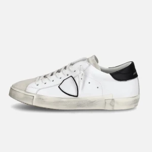 Philippe model - Stilrena vita sneakers från Philippe Model med svart hälkappa och kontrasterande logodetalj på sidan. Skorna har snörning, rund tå och platt sula. Tillverkade i skinn med mockadetaljer framtill för en cool och urban look.