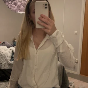 Vit blus från NA-KD - Säljer en stilren vit blus från NA-KD i storlek 38. Blusen har långa ärmar och knappar framtill. Perfekt för en chic och enkel look. 💫 svängda armar nertill. 