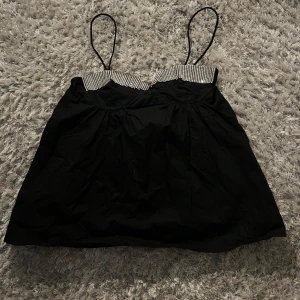 Svart linne med strassdetaljer från zara - Snygg svart linne med tunna axelband och glittrande strassdetaljer vid bysten. Perfekt för en kväll ute eller en speciell tillställning. Nån enstaka strassdetalj är en aning lösa