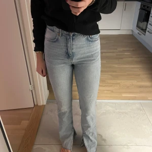 Ljusblå jeans med hög midja - Snygga ljusblå jeans med hög midja och klassisk femficksdesign. Slits längst ner. Från Gina tricot.