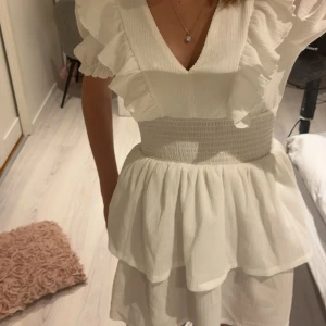 Vit klänning från Gina Tricot - Säljer en söt vit klänning från Gina Tricot i storlek XS. Klänningen har volanger och en v-ringning med korta armar. Perfekt nu till skolavslutningen eller studenten. Den är i jätte bra skick och bara använd en gång. Jag är 170 och klänningen slutar strax innan knäna 💗