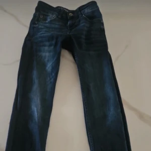 Mörkblå jeans från Garcia - Snygga mörkblå jeans från Garcia med klassisk femficksdesign och knappgylf. Perfekta för en avslappnad stil. Märkeslogga på baksidan av midjan.