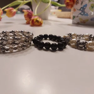 Tre armband med pärlor och stenar - Säljer tre eleganta armband. Ett med svarta pärlor, ett med vita och silverfärgade pärlor samt ett med större vita och silverfärgade pärlor och dekorativa detaljer. Perfekta för att ge en stilren touch till din outfit. Skriv om ni har någon fundering!✨️