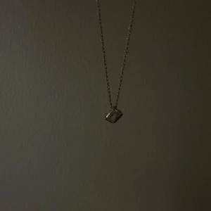 Silverhalsband från Pandora  - Elegant silverhalsband med ett fyrkantigt hängsmycke. Kedjan är tunn och smidig, vilket gör den bekväm att bära. Har enbart provat halsbandet, annars är det oanvänt. 