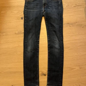 Levi's 510 Skinny Jeans - Snygga Levi's 510 skinny jeans i mörkblå denim. De har en tight passform och klassisk femficksdesign. Perfekta för en stilren look. L32 W28.