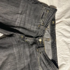 Grå jeans från Lee - Säljer ett par grå jeans från Lee.  Jeansen är low waist och straight/bootcut. De är i bra skick,säljer då de inte längre kommer till användning. Hör gärna av er vid funderingar🩷