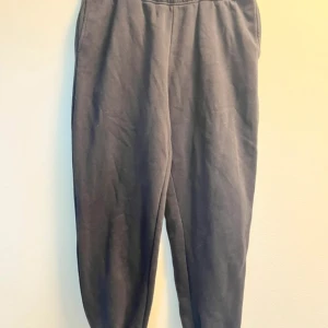 Svarta mjukisbyxor från Gina Tricot - Bekväma svarta mjukisbyxor från Gina Tricot med elastisk midja. Perfekta för en avslappnad stil och tillverkade i ett mjukt material som ger en skön känsla hela dagen.