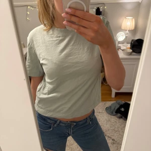 Ljusgrön croppad t-shirt - Säljer en ljusgrön t-shirt. Perfekt för en avslappnad stil. Passar bra till jeans eller shorts. Inga defekter och i storlek S. 