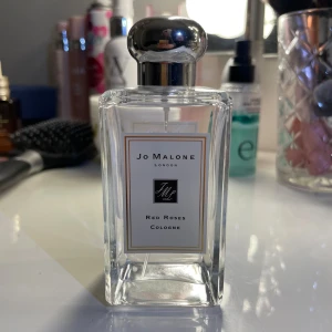 Red Roses Cologne från Jo Malone - Elegant parfymflaska från Jo Malone med doften Red Roses. Flaskan är genomskinlig med en stilren etikett och har en silverfärgad kork. Perfekt för den som älskar en klassisk och tidlös rosdoft.