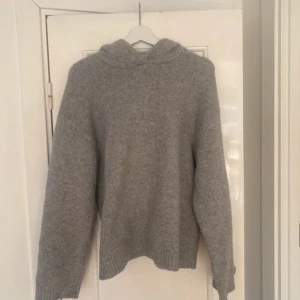Grå stickad hoodie - Grå stickad hoodie.  Tröjan har långa ärmar och en bekväm huva. Helt ny och aldrig använd. Säljer pga att den bara blivit hängandes i garderoben 🤗💕 är storlek S men skulle säga att den passar XS och M också