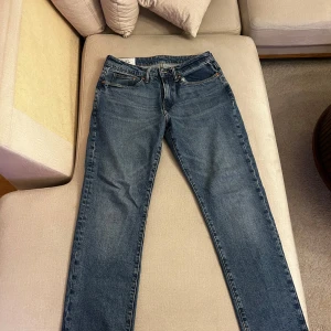 Blå jeansbyxor - Klassiska blå jeans med en straight passform. De har en traditionell femficksdesign och en knappgylf. Perfekta för en avslappnad stil.