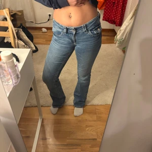 Blå jeans med bootcut - Snygga blå jeans med bootcut-stil och låg midja. Storlek 164 och har justerbar midja innuti, passar mig som ofta har 36 och 34 i jeans. Jag är 161 cm och de passar i längden. Använda 2 gånger